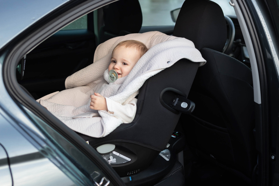 Baby met poncho in autostoel
