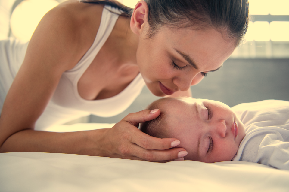 mama die aan het hoofdje van baby ruikt