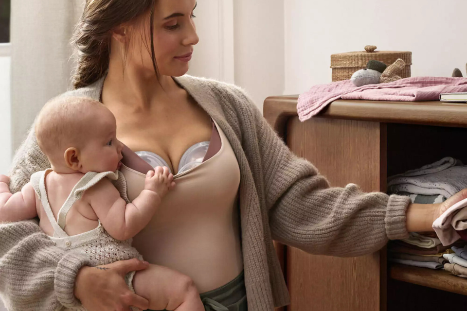 mama die aan het kolven is met baby in haar armen