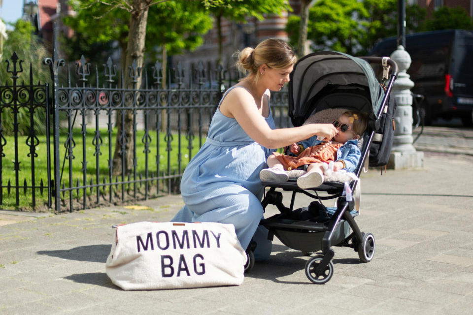 mama met mommy bag en kindje in kinderwagen