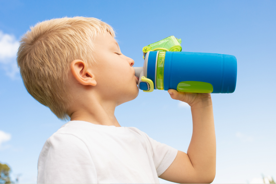 jongetje die drinkt van een drinkfles