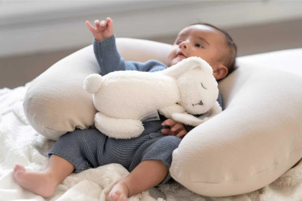 baby met een warmtekruik en een voedingskussen