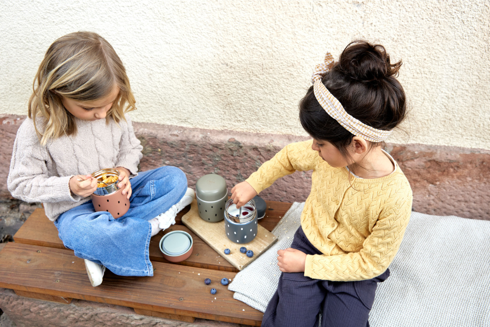 twee meisjes die uit food jars eten