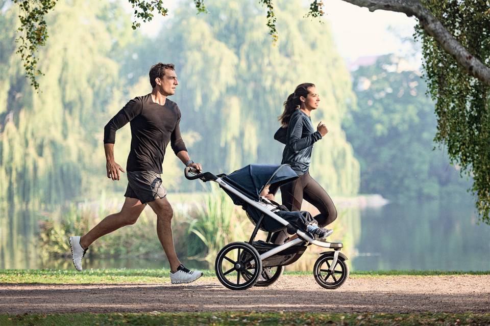 ouders die hardlopen met een kinderwagen