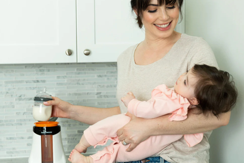 mama en baby met flesverwarmer
