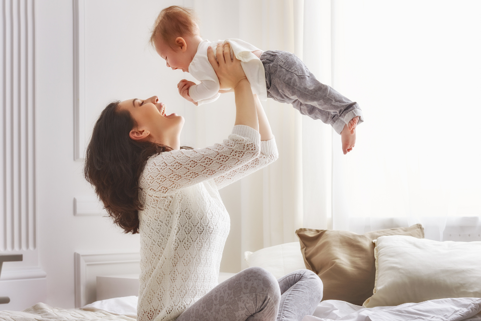 mama die baby in de lucht opheft