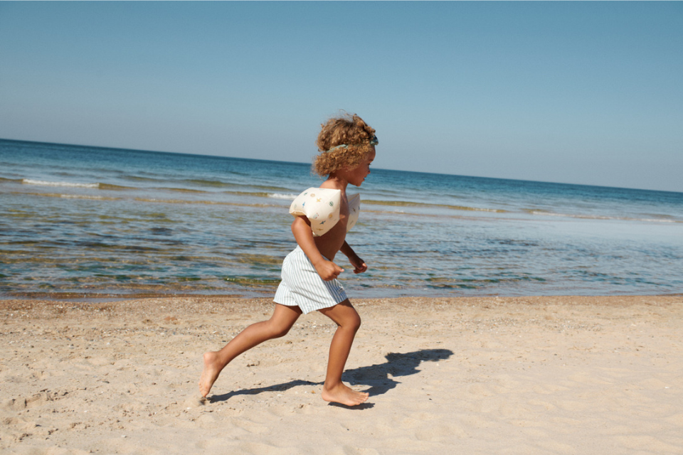 jongetje dat op het strand loopt